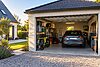 Garage séparé d'une maison avec une voiture et des biens entreposés