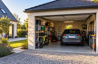 Garage séparé d'une maison avec une voiture et des biens entreposés